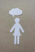 The silhouette of a woman in a dress made of white paper, cut by hand. With speech-bubble in the center of vertical photo