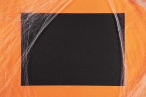 Orange and black paper background with cobwebs for Halloween photo