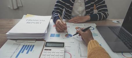 Close up photo of business working group of people are discussing together pointing at financial report, top or above view