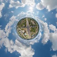 tiny planet in sky with clouds overlooking old town, urban development, historic buildings and crossroads. Transformation of spherical 360 panorama in abstract aerial view. photo