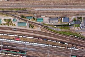 aerial view over long railway freight trains with lots of wagons stand on parking photo