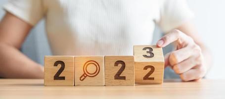2022 change to 2023 block with magnifying glass icon. SEO, Search Engine Optimization, hiring , Advertising, Idea, Strategy, marketing, Keyword, Content and New Year start concepts photo