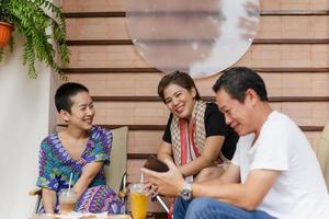 Friends having a great time smiling and drinking coffee and juice in cafe. photo