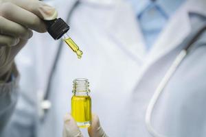 médico revisando y analizando con una gota una planta de cáñamo biológica y ecológica utilizada para el aceite de cbd farmacéutico a base de hierbas en un laboratorio. foto