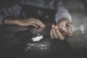 A needle in a human hand. Stop drug addiction concept.  International Day against Drug Abuse. Stop using illegal drugs. photo