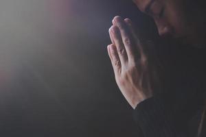 Praying hands with faith in religion and belief in God on dark background. Pay respect.  Namaste or Namaskar hands gesture. photo