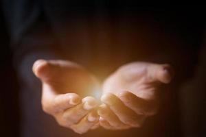 Man hands praying in dark background with faith in religion  in God. Power of hope or love. photo