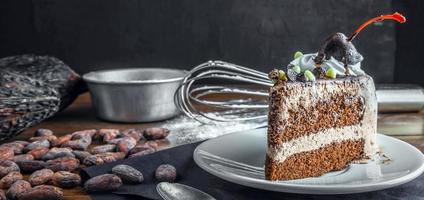 Slice of tasty homemade chocolate cake on the plate and Contain cocoa beans and starch as ingredients for cooking chocolate cakes on the table photo