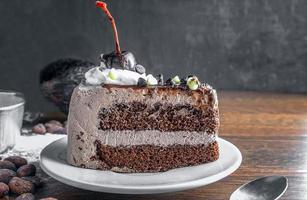 Slice of tasty homemade chocolate cake on the plate and Contain cocoa beans and starch as ingredients for cooking chocolate cakes on the table photo