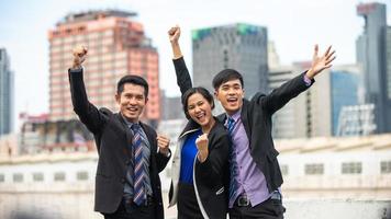 hombres y mujeres de negocios asiáticos expresan alegría y felicidad en el trabajo exitoso fuera de la oficina foto