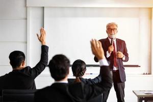 empresario y mujer de negocios levanta la mano para hacer una pregunta a la reunión. foto