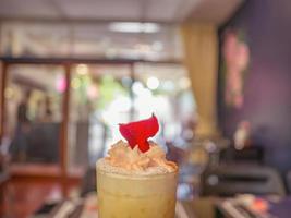 Close up Ice Coffee topping with whip cream and Rose leaf in Coffee cafe photo