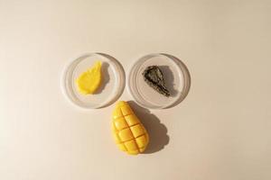 Two cosmetic smudges of body scrub and a natural mango soap lying on a beige background photo