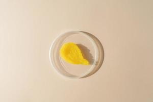 A yellow smudge of a mango body scrub  lying on a plate on a beige background photo