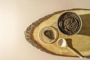 A body care natural chocolate scrub for spa procedures lying on a wooden plate photo