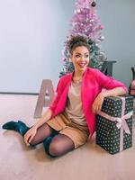 alegre mujer afroamericana en el fondo del árbol de navidad. navidad, año nuevo, felicidad, concepto de vacaciones foto