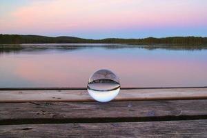 bola de cristal en un muelle de madera en un lago sueco a la hora de la tarde. naturaleza escandinavia foto