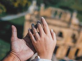 una pareja tomándose de la mano contra un antiguo castillo foto