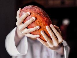 vista cercana de un hombre que sostiene el mango japonés rojo expansivo foto