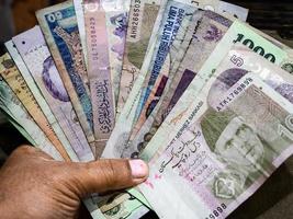 A close-up view of a hand holding asian countries bank notes photo