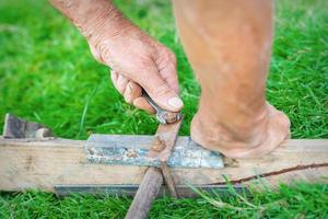 Elderly man twists the nut by wrench photo