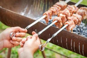 Hands of man prepares barbecue meat photo