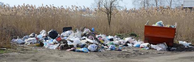 el bote de basura está lleno de basura y desechos. retiro intempestivo de basura en zonas pobladas foto