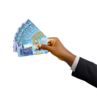 Black hand with suit holding 3D rendered Kuwaiti dinar notes isolated on transparent background png