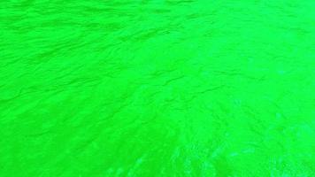 Defocus blurred transparent green colored clear calm water surface texture with splashes and bubbles. Trendy abstract nature background. Water waves in sunlight. Green water shining background. video