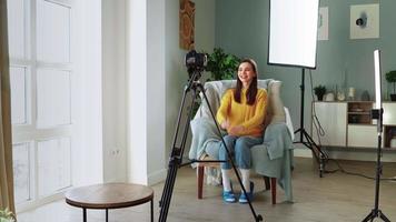 mooi meisje blogger filmen haar video blog. vrouw influencer creëert online opleiding Cursus voor afgelegen werk. aantrekkelijk vrouw in geel trui bloggen. afstand onderwijs en e-learning concept.