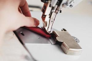 A leather craftsman produces leather goods on a sewing machine in his shop. photo