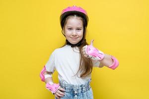 little girl in a protective helmet and elbow pads shows like