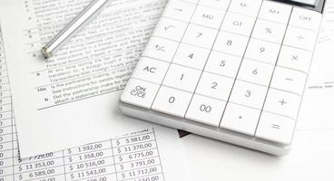 Business concept - financial report and pen, calculator and charts photo