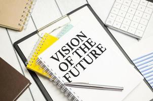 Vision Of The Future words on white notebook with colourful notepads and calculator photo