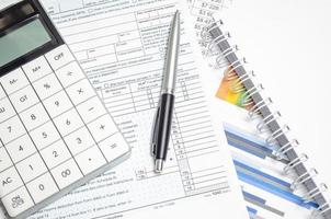 US Individual Tax Return Form 1040 with calculator, pen and charts photo