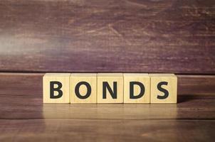 Concept of bonds. Word bonds on wooden blocks and wooden background photo
