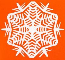 white snowflake on orange paper photo