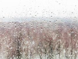 gotas de agua de la nieve derretida en el cristal de la casa foto