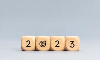 2023 year goals concept. Wooden blocks with 2023 number and goal target icon on gray background. Copy space photo