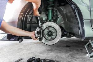 Hand a technician man repairing action and service disk brake for car,change Brake pads and system check in basic maintenance photo