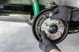 cerrar la mano un hombre cambiar el rodamiento de la rueda en el concepto de mantenimiento del coche foto