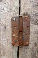 rusty metal door hinge. Door hinge on a wooden wall. photo