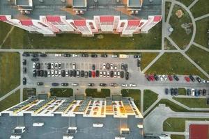 vista aérea del estacionamiento de automóviles cerca de la construcción de viviendas modernas