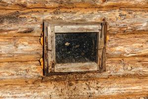 pequeña ventana en una pared de troncos. cobertizo para animales. foto