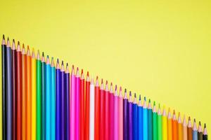 Many different colored pencils on a yellow background. Place your text. photo