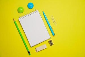 Top view photo open notepad ballpoint pen on yellow background with copy space.