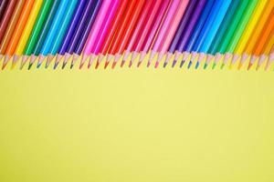 Many different colored pencils on a yellow background. Place your text. photo