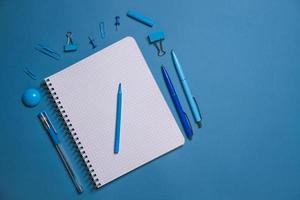 papelería. cuaderno abierto, lápices y bolígrafos, pegatinas y clips de encuadernación. Copiar foto