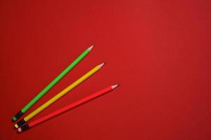 Colored wooden pencils on red background, education concept. photo