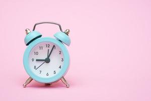 Blue alarm clock on a pink background. Copy space. Close-up. Deadline concept. photo